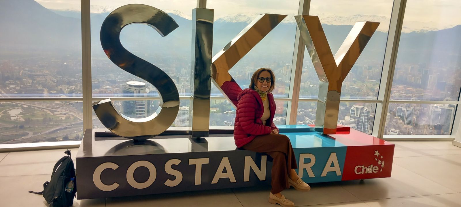 Dr Elżbieta Wilczyńska in front of the mountains at the Costanera Center, the tallest building in South America, in 2024