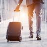 The picture shows a man at the airport with a luggage in his hands