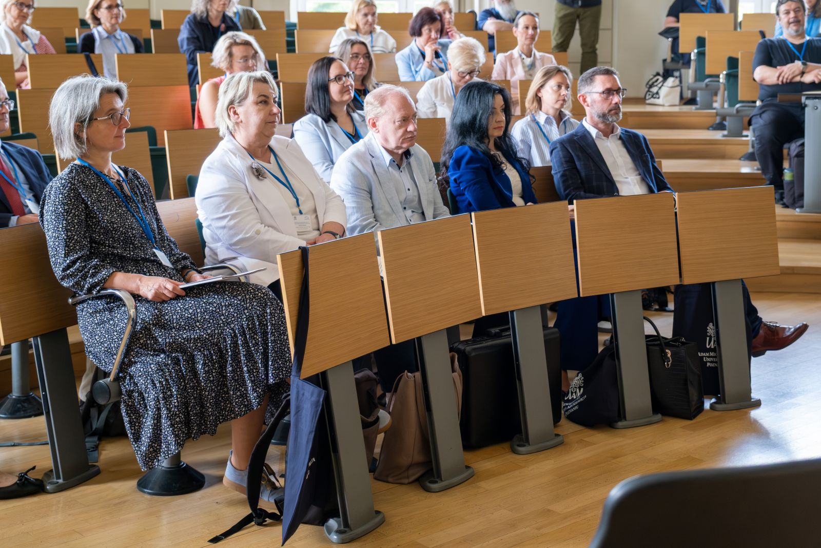 Grupa uczestników konferencji w sali wykładowej.