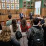 Grupa studentek i studentów słucha wypowiedzi Prorektora