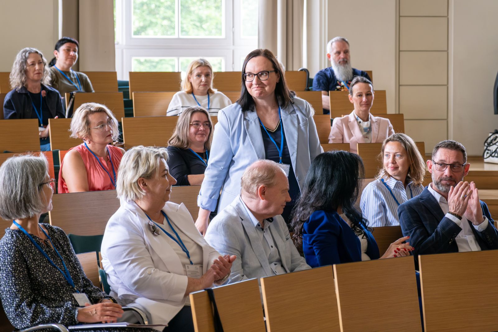 Grupa uczestników konferencji w sali wykładowej.