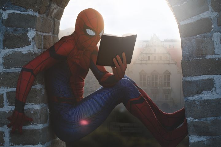 Spider-Man czytający komiks na dachu Biblioteki Uniwersyteckiej UAM z widokiem na Collegium Minus.
