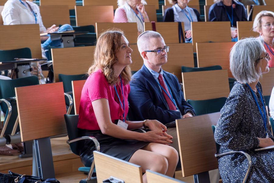 Grupa uczestników konferencji w sali wykładowej.