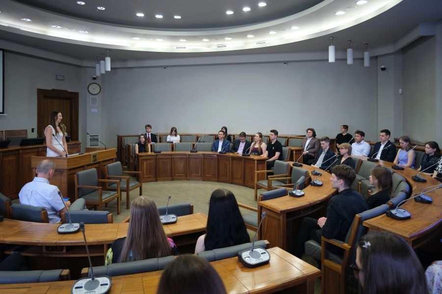 Grupa nagrodzonych osób siedzi w Sali Senatu UAM