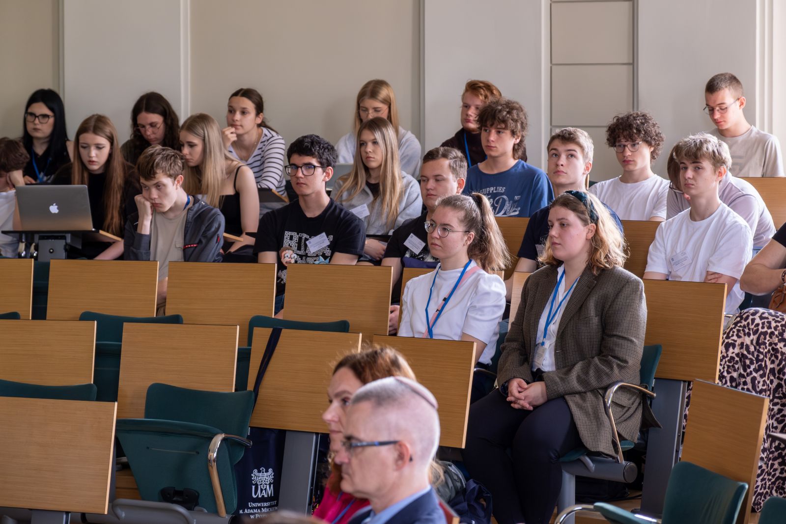 Grupa uczestników konferencji w sali wykładowej.