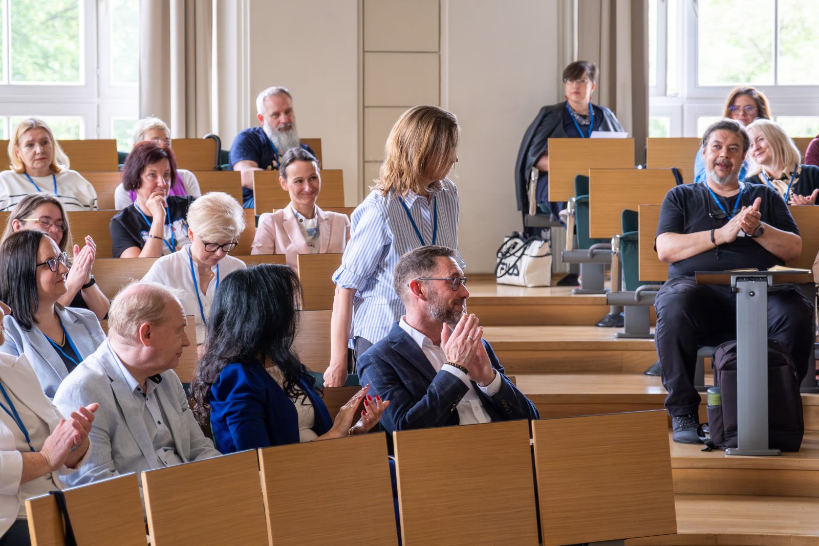 Grupa uczestników konferencji w sali wykładowej.