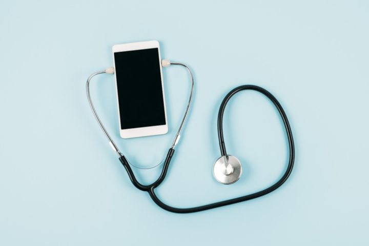 Smartfon otoczony stetoskopem.