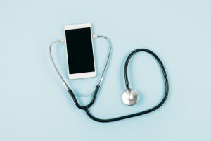 Smartfon otoczony stetoskopem.