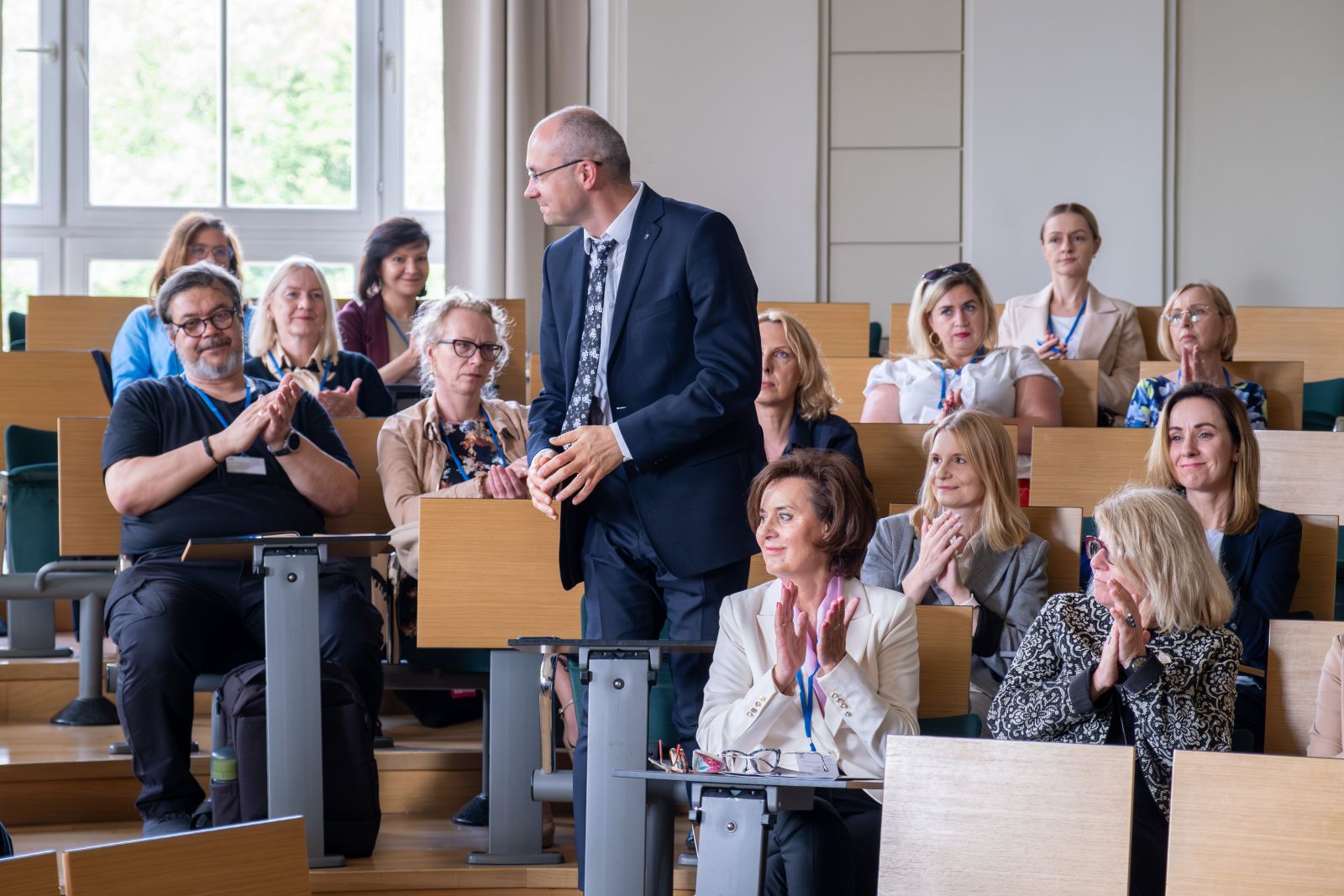 Grupa uczestników konferencji w sali wykładowej.