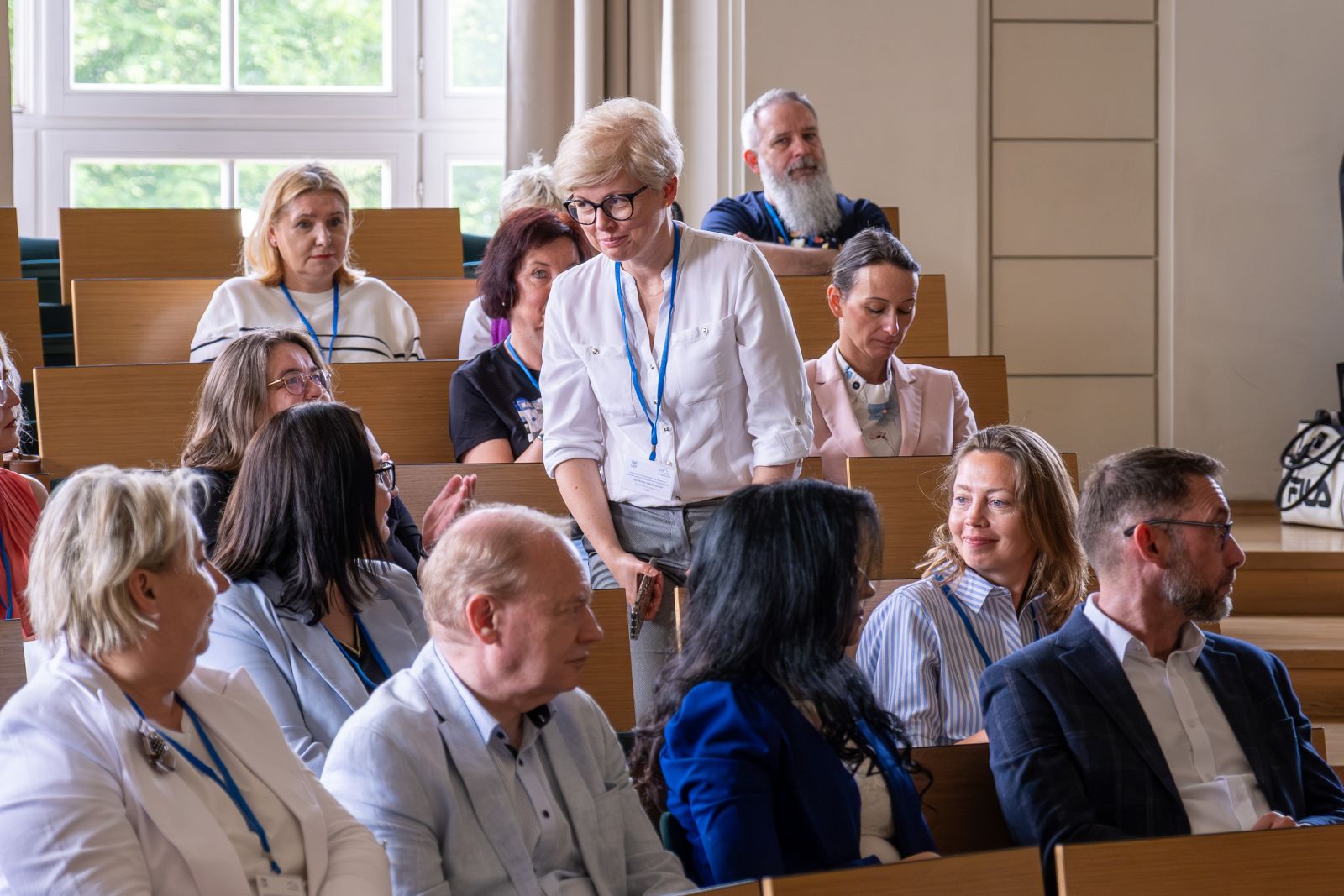 Grupa uczestników konferencji w sali wykładowej.