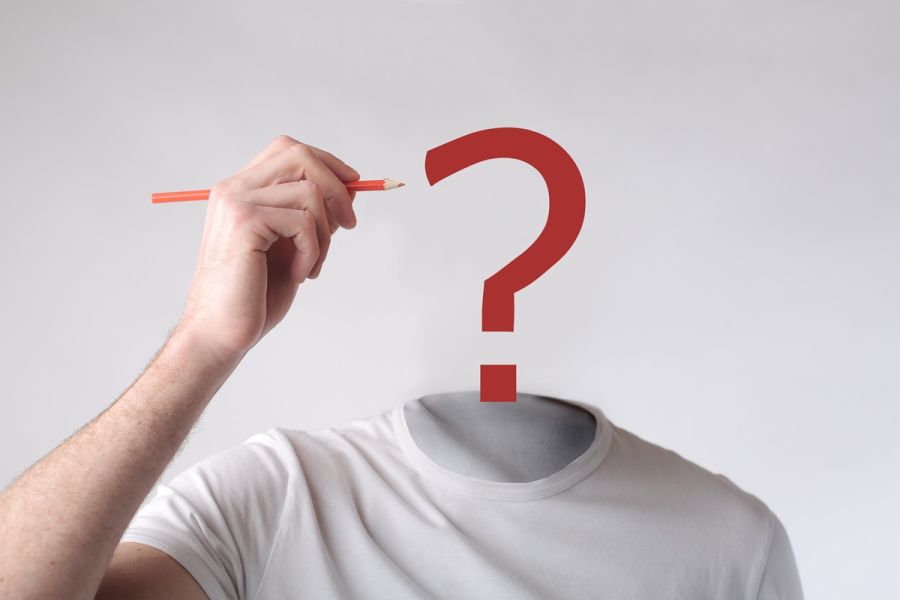 Sylwetka osoby bez głowy, nad której szyją widnieje czerwony znak zapytania, a obok uniesiona dłoń trzyma ołówek.