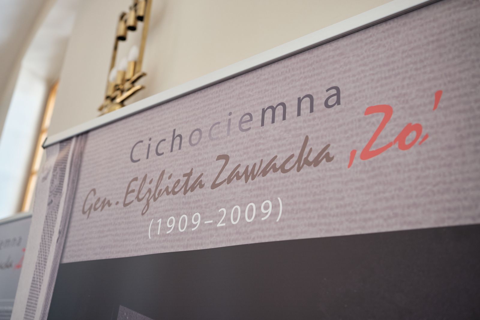 Fragment planszy wystawowej z napisem „Cichociemna Gen. Elżbieta Zawacka (1909–2009)” widoczny w zbliżeniu na jasnym tle.