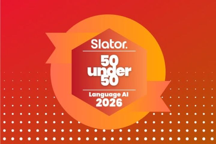 Graphic with a red‑to‑orange gradient background and a pattern of white dots at the bottom. In the center, a hexagonal badge with ribbon‑like extensions displays the text: “Slator. 50 Under 50. Language AI. 2026