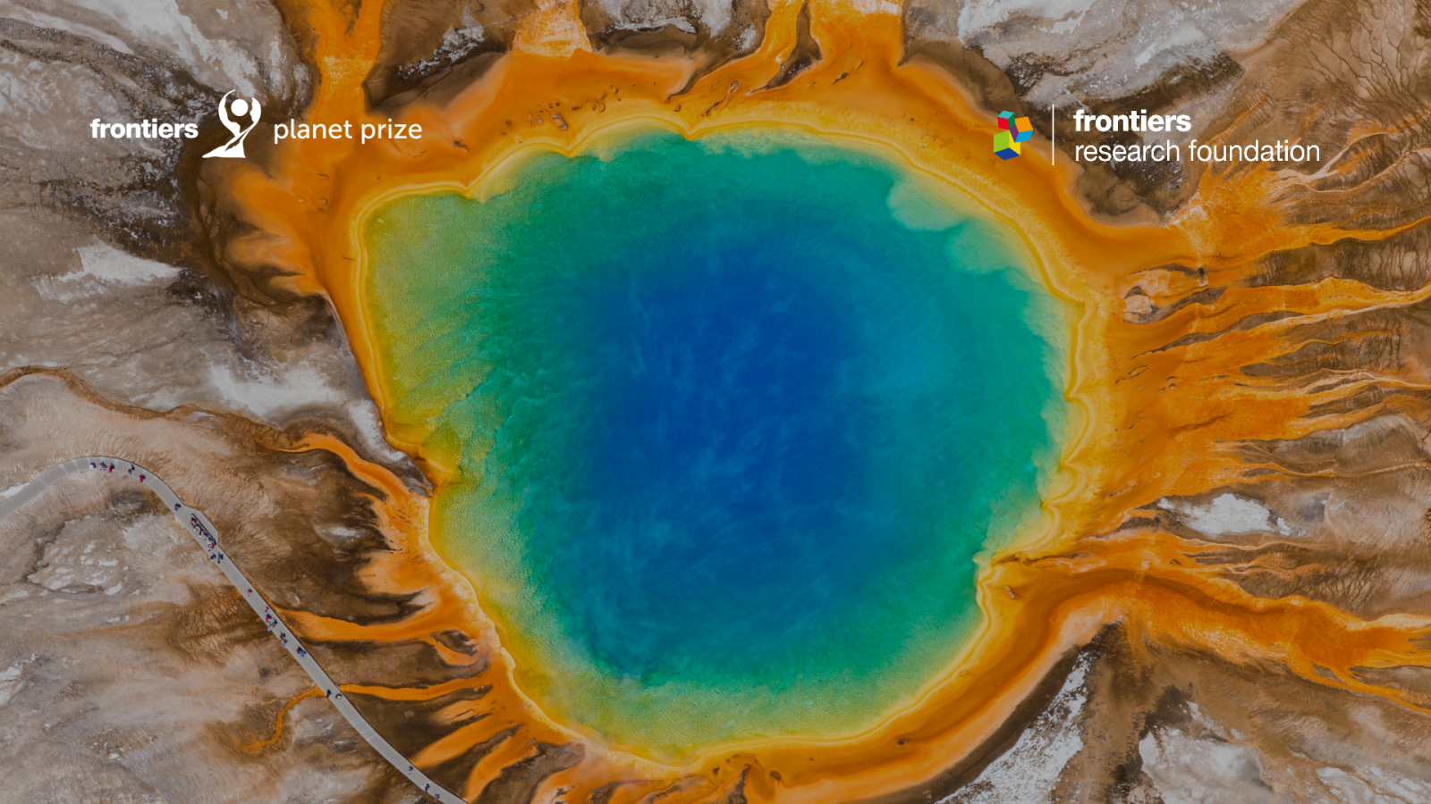 The photo shows an impact crater lake filled with colorful - blue, green and orange water with a Frontier Group logotype on the left up corner. 