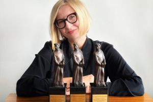 Dr Katarzyna Remiszewska. Przed nią postawione na stole 3 statuetki.