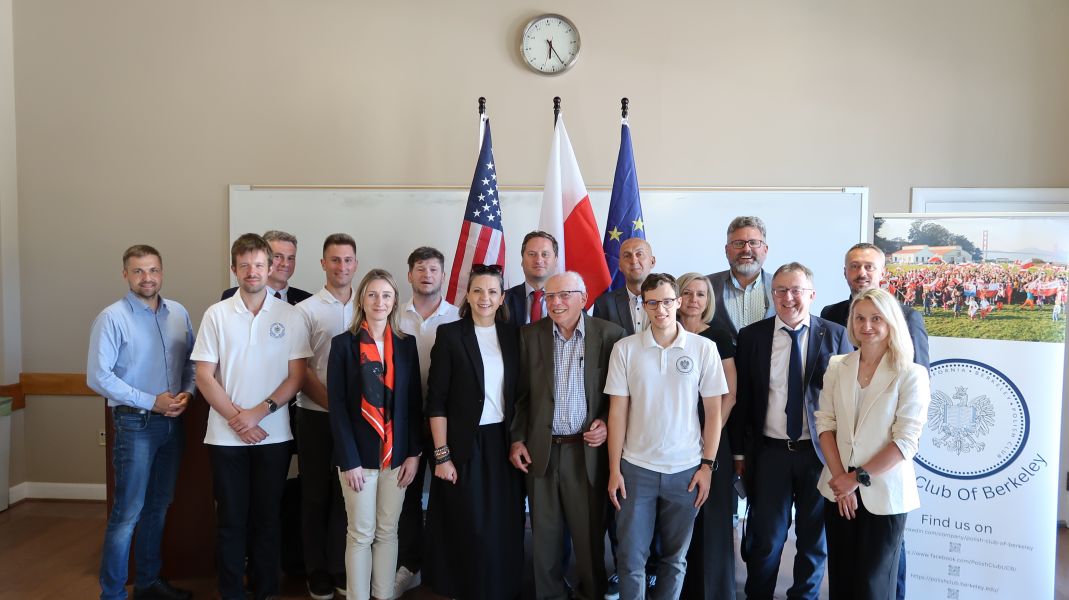 Uczestnicy delegacji, zdjęcie grupowe przed flagami: UE, Polski i USA