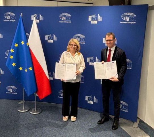 The AMU Rector, Prof. Bogumiła Kaniewska, and Witold Naturski, Head of the European Parliament’s Office in Poland, sign a cooperation agreement against a backdrop of the flags of the European Union and Poland. 
