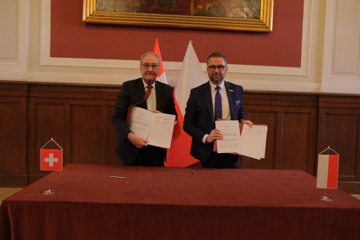 Wiceprezydent Konfederacji Szwajcarskiej, Radca Federalny Guy Parmelin oraz minister NiSW Marcin Kulasek trzymają podpisane egzemplarze dokumentu