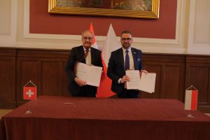 Wiceprezydent Konfederacji Szwajcarskiej, Radca Federalny Guy Parmelin oraz minister NiSW Marcin Kulasek trzymają podpisane egzemplarze dokumentu